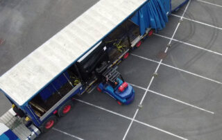 An ariel view of a forklift loading a Q5D CY10W onto a large blue truck