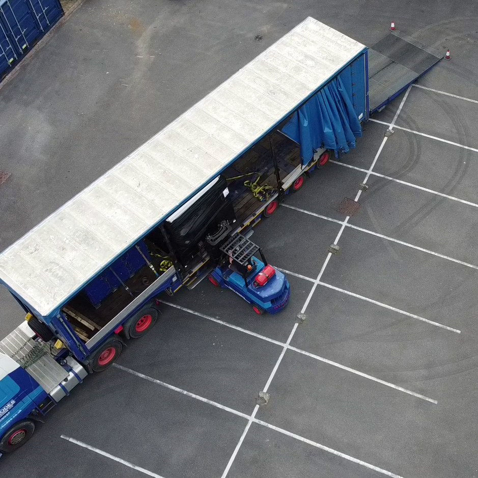 An ariel view of a forklift loading a Q5D CY10W onto a large blue truck